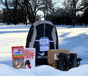 A birding kit, featuring a backpack, binoculars with case, a quick start guide, and a reference book.