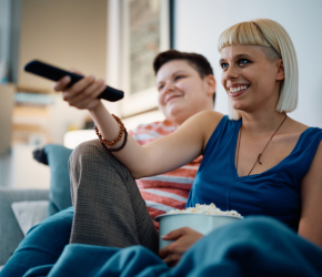 A couple watching a movie at home, using the Kanopy App.