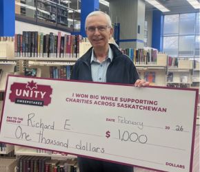 A man holding a large cheque for a thousand dollars