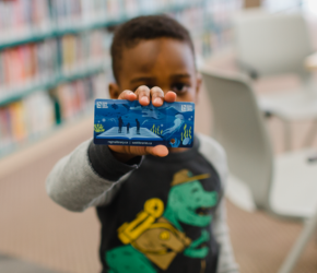 A child holding a library card