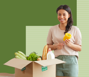 A smiling woman unpacking her REACH Good Food Box.